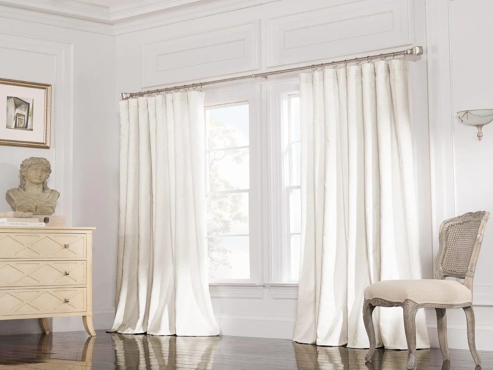 Elegant white drapes in bright room.